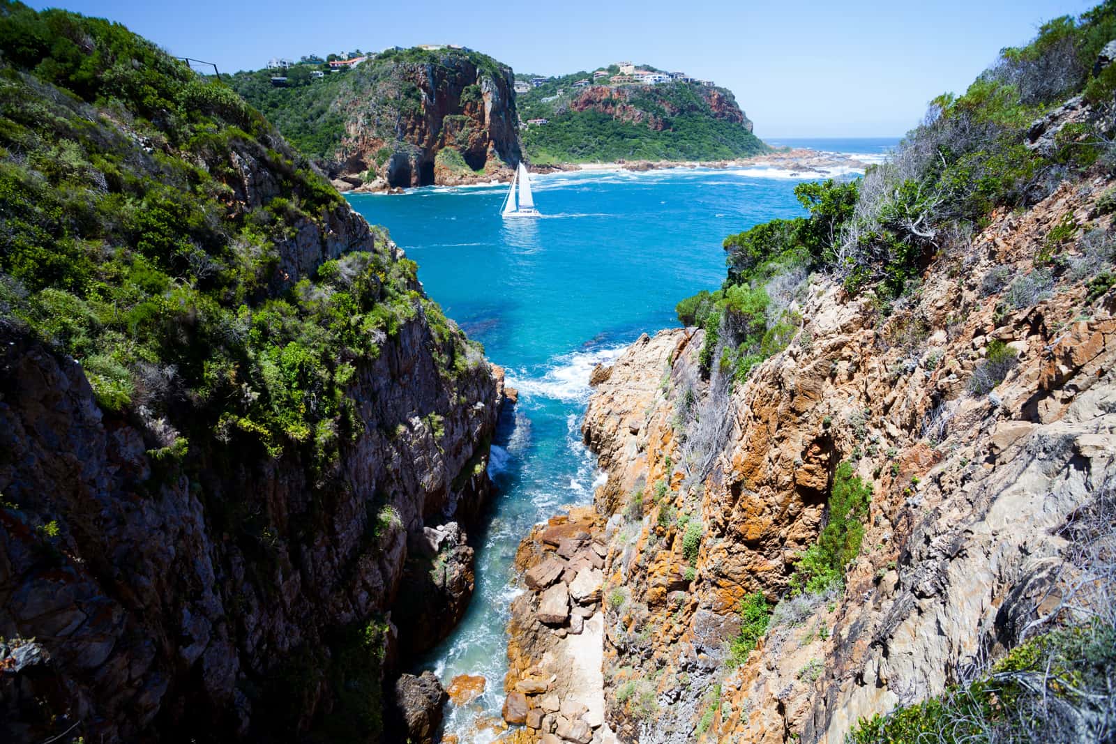 Felsige Bucht mit Segelboot an der Küste bei Knysna
