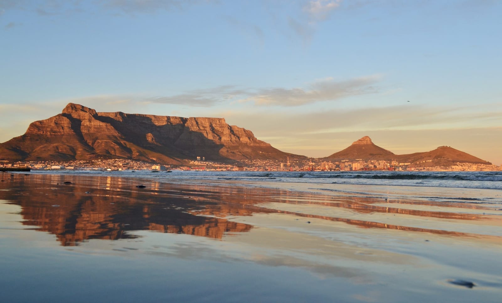 Tafelberg und Lion's Head im Morgenlicht, gespiegelt im nassen Strand