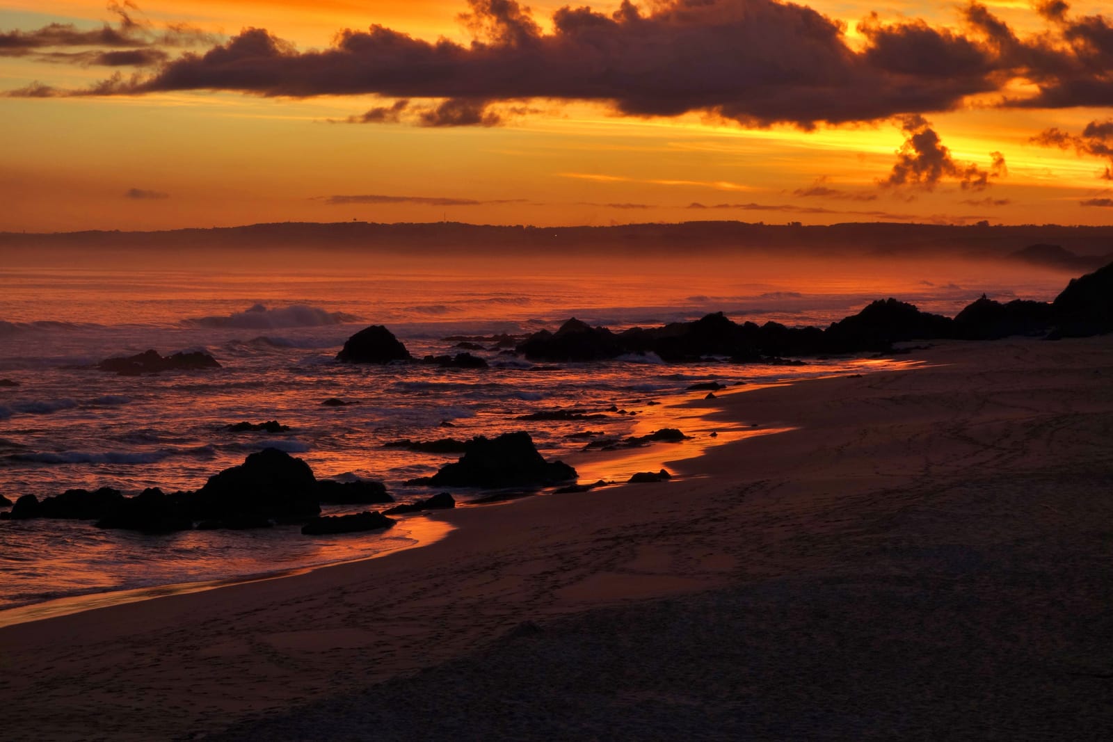 Felsiger Strand bei Plettenberg Bay im Abendrot
