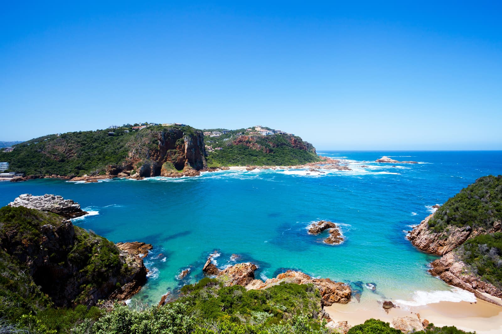 Türkise Bucht unter den bewaldeten Klippen der Knysna Heads