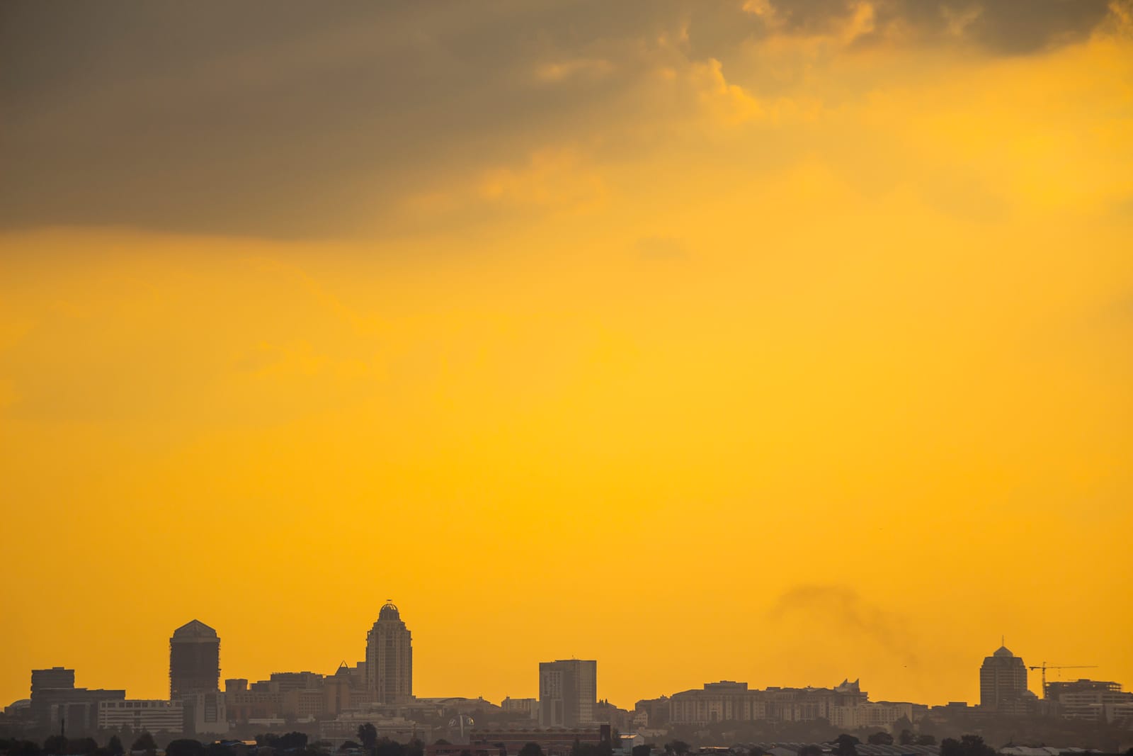 Silhouette der Hochhäuser von Sandton unter orangem Abendhimmel
